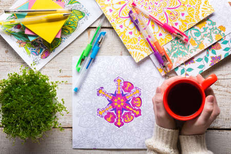 Woman coloring an adult coloring book, new stress relieving trend, mindfulness concept, hand detailの写真素材