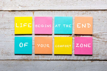 Retro white wooden table with motivational quote on colorful sticky notesの写真素材
