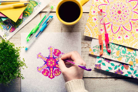 Woman coloring an adult coloring book, new stress relieving trend, mindfulness concept, hand detailの写真素材