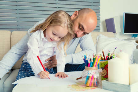 Father and daughter drawing together, creativity and learning conceptの写真素材