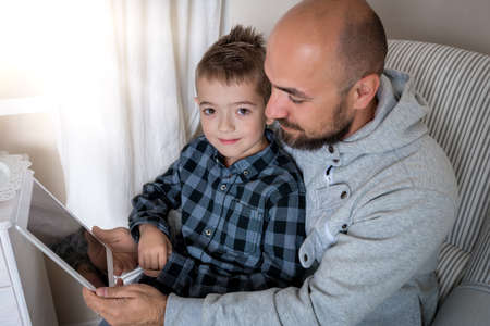 Father and son playing with digital tabletの写真素材