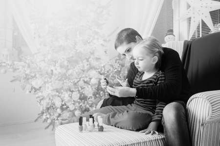 Mother and daughter having fun painting finger nails on xmas dayの写真素材