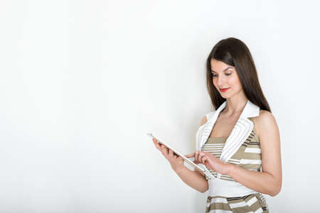 Elegant young business woman using digital tablet, business portrait on white background