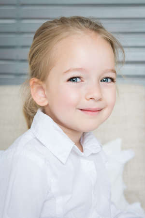 Adorable blond preschool girl portrait, smiling child, candid natural portraitの写真素材
