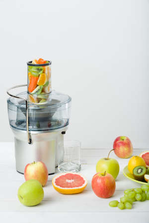 Modern electric juicer and various fruit on kitchen counter, healthy lifestyle conceptの写真素材