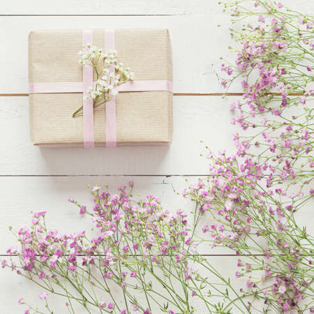 White wooden table with pink flowers and a present, mother's day conceptの写真素材