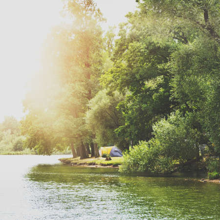 Camping tent near a beautiful lake, summer campsite, adventure family vacation conceptの写真素材