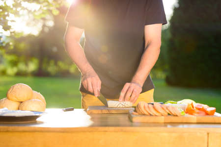 Young hipster man preparing food for garden grill party, summer barbecue conceptの写真素材