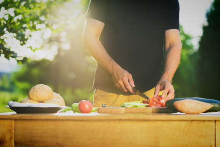 Young hipster man preparing food for garden grill party, summer barbecue conceptの写真素材