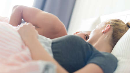 Young sensual couple in their bedroom looking lovingly at each other, sex concept