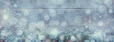 Snowy Christmas Background, Fir Tree Branches And Light Bokeh On Wooden Background, Festive Banner With Copy Spaceの写真素材