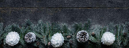 Snowy Christmas Background, Fir Tree Branches With Pine Cones And Xmas Baubles On Wooden Background, Festive Banner With Copy Spaceの写真素材