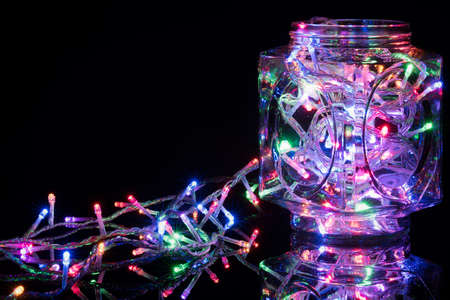 Christmas lights on reflective black background. Holiday shiny garland border. Xmas ligts concept