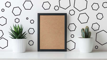 Modern room decoration. Various cactus and succulent plants in different pots. Mock-up with a black frame. Scandinavian home decor.の写真素材