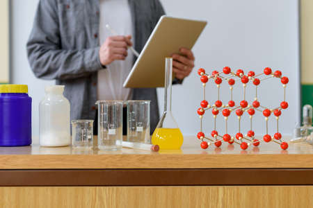 Teacher using digital tablet to teach students in chemistry class. Education, VR, Tutoring, New...
