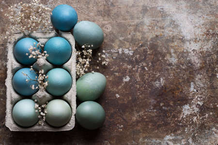 Happy Easter rustic concept with copy space. DIY dyed various shades of blue Easter eggs on retro...