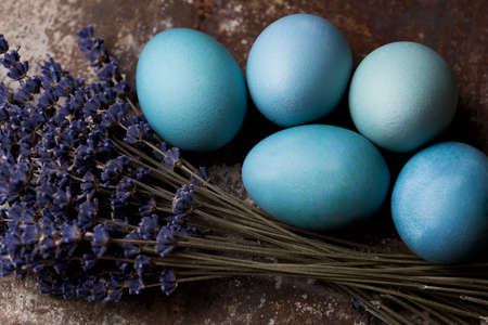 Happy Easter rustic concept with copy space. DIY dyed various shades of blue Easter eggs on retro rusty metal background. の写真素材