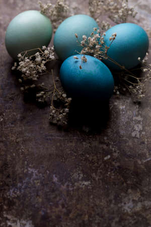 Happy Easter rustic concept with copy space. DIY dyed various shades of blue Easter eggs on retro...