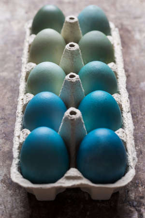 Happy Easter rustic concept. DIY dyed various shades of blue Easter eggs on retro rusty metal...