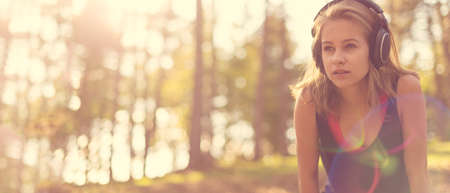 Young attractive sportswoman listening to music wearing headphones. Sport, fitness, workout web...