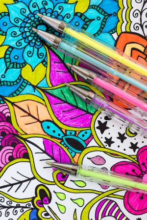 Adult coloring book, new stress relieving trend. Art therapy, mental health, creativity and mindfulness concept. Adult coloring page with pastel colored gel pens, Flat lay background.の写真素材