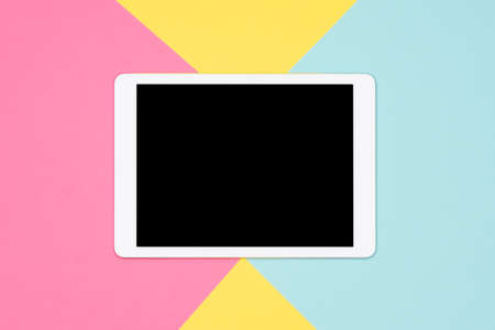 Digital tablet with blank screen mock up flat lay on pastel colored background. Tablet on colorful background , top view.の写真素材