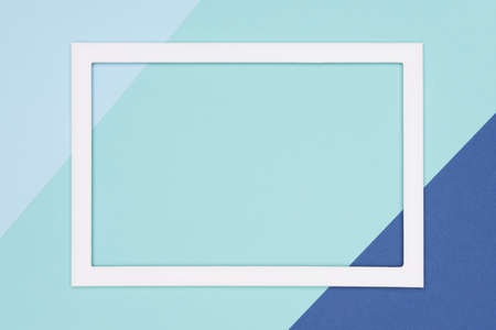 Abstract geometrical flat lay pastel blue and turquoise colored paper background. Minimalism template with empty picture frame mock up.の写真素材