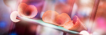 Empty sweet ice cream cones on display in gelateria. Icecream cones dreamy pink bokeh web banner....
