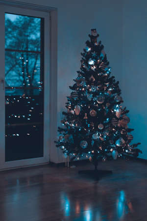 Beautiful decorated and illuminated Christmas tree at night. Christmas interior background.