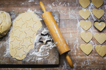 Christmas baking. Making gingerbread biscuits. Cookie dough, cookie cutters and rolling pin on...