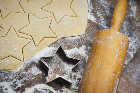 Christmas baking. Making gingerbread biscuits. Cookie dough, cookie cutters and rolling pin on...