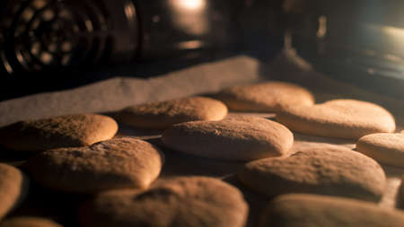 Christmas cookies baking in the oven. Christmas baking. Gingerbread biscuits on baking tray.の写真素材