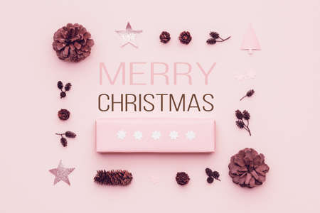 Pastel pink minimal christmas background. Beautiful christmas gift isolated on pastel pink background. Pink colored wrapped xmas box composition.の写真素材
