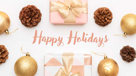 Pink and gold christmas gifts isolated on white background. Wrapped xmas boxes, christmas baubles and pine cones. Christmas composition with copy space.の写真素材
