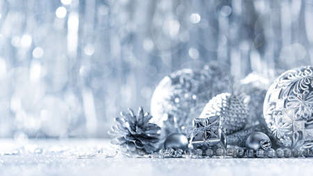 Shiny silver christmas present and beautiful ornaments, with defocused christmas lights in the background. Christmas banner.の写真素材