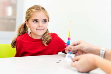 Elementary Age Girl in Child Occupational Therapy Session Doing Playful Exercises With Her...