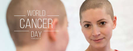 Young adult female cancer patient looking in the mirror, smiling, happy about her new short hair....