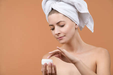 Beautiful woman applying anti aging moisturizer on her face. Beauty and skin care concept.の写真素材