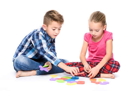 Cute children playing with large colorful alphabet letters on white background. Kids speech therapy concept. Speech impediment, logopedy, dyslexia background.の写真素材