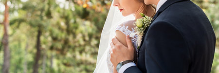 Cropped shot of an affectionate young newlywed couple embracing eachother on their wedding day. Just married husband and wife panoramic banner. Wedding and love concept.の写真素材