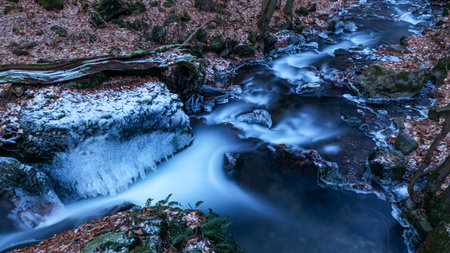 Long exposure of a beautiful frozen forest stream.の写真素材