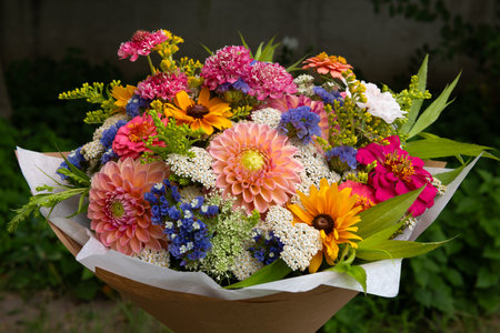 Summer bouquet. Beautiful multi colored fresh flower arrangement. Birthday bouquet made of summer flowers photographed outdoors.の写真素材