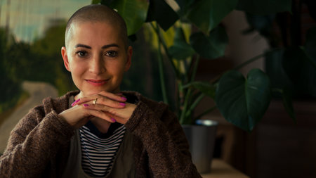 Beautiful young positive female cancer survivor smiling indoors portrait. Mental health, life balance, mindfulness and mindreset concept.の写真素材