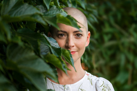 Beautiful young positive female cancer survivor smiling outdoors portrait.の写真素材