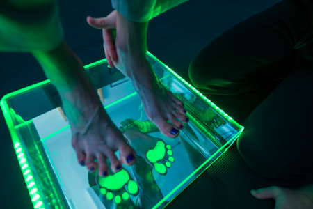 Pedobarography analysis shows the distribution of plantar pressure of the foot. Barefoot woman standing on podometer having feet checked at physical therapy session.の写真素材