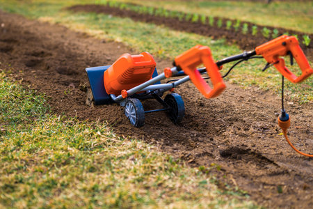 Garden tiller, rotary tiller, mini cultivator or rotavator. Tillers break up compacted soil, improve its structure and aeration. This allows for better water infiltration, drainage and prepares ground for planting.の写真素材