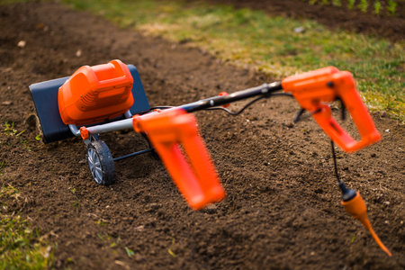 Garden tiller, rotavator or cultivator. Tillers break up compacted soil, improve its structure and aeration. This allows for better water infiltration, drainage and prepares ground for planting.の写真素材