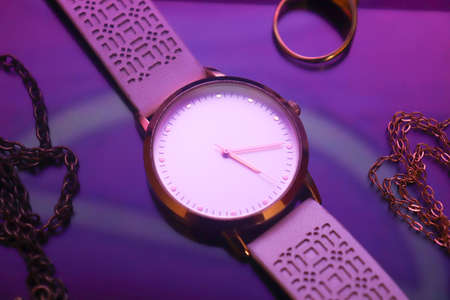 white clock with jewelry in a purple backgroundの写真素材