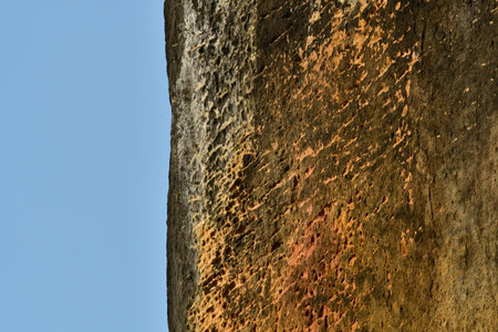 Vertical rock cliff with blue sky background pattern structure. High quality photo
