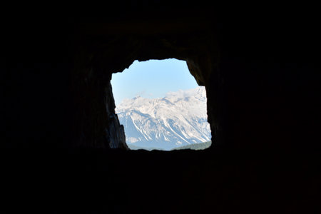 View from hole in cave tunnel to dolomite mountains high contrast. High quality photoの写真素材
